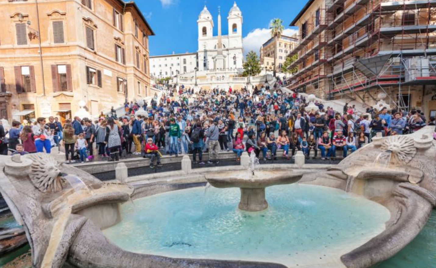 A large group of people gathered around a fountain in a city

Description automatically generated with low confidence